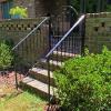 Patio Gate at the top of steps and handrails leading down the steps from the back patio.